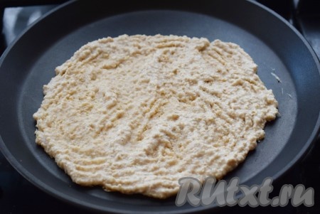 Равномерно разравниваем овсяную массу по периметру сковороды вилкой.