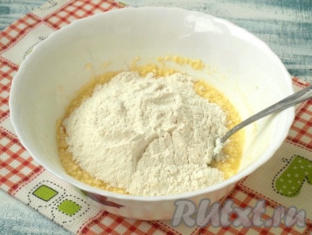 Далее добавляем соду, гашеную уксусом, и просеиваем муку. Размешиваем тесто ложкой.
