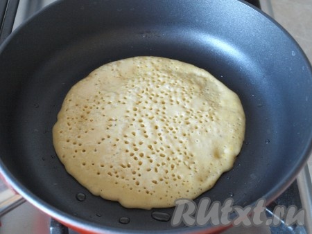 Перед первым блином хорошо нагреть сковороду и смазать маслом. Половником наливать тесто и наклонять сковороду так, чтобы тесто равномерно распределилось. Жарить тыквенный блинчик до того момента, пока пропадут влажные участки и на поверхности появится много пор.