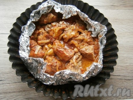 Свинину в фольге разместить на противне или в форме для запекания и отправить в разогретую до 200 градусов духовку. Запекать 30 минут при этой температуре. Затем края фольги развернуть и дать мясу подрумяниться в течение 30 минут, снизив немного температуру - до 180 градусов. В самом конце шашлык посолить и перемешать.
