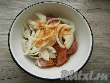 Посыпать мясо специями для шашлыка, перемешать. Добавить нарезанный полукольцами очищенный лук, сверху немного его посолить и посыпать сухой аджикой.
