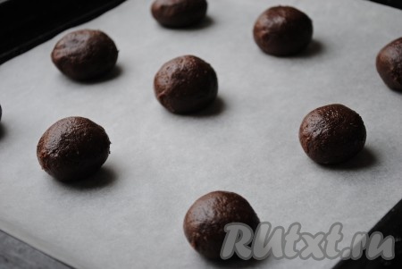 Мокрыми руками сформировать из теста шарики размером с грецкий орех. Выложить на противень, застеленный пергаментной бумагой, на небольшом расстоянии друг от друга.