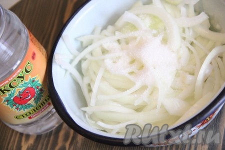 Выложить лук в глубокую миску и добавить уксус, воду и сахар.