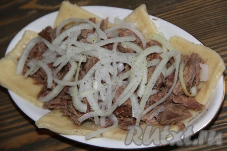 Маринованный лук откинуть на дуршлаг, а затем выложить поверх мяса.
