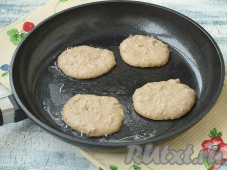 Сковороду разогреть и смазать маслом при помощи кисточки, уменьшить огонь до среднего. Столовой ложкой выкладывать тесто на сковороду в виде круглых оладий. Затем дождаться, когда низ оладушек хорошо подрумянится (на это потребуется 2-3 минуты).