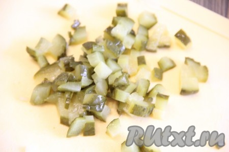 Маринованные огурчики мелко нарезать и выложить на лук.
