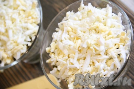 Яйца, натертые на крупной тёрке, выложить поверх огурцов и сделать сеточку из майонеза.
