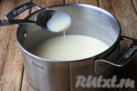 Отправить кастрюлю на огонь и на среднем огне довести до кипения, постоянно помешивая венчиком. Затем огонь уменьшить до минимального и варить 8-10 минут, помешивая. Если вы хотите получить сгущённое молоко, похожее по консистенции на покупное, то хватит и 8 минут, если более густое - варите, помешивая, 10 минут, но не забывайте, что после остывания домашняя сгущенка из сухого молока станет ещё более густой. На фото горячая сгущёнка, проваренная 8 минут с момента закипания.
