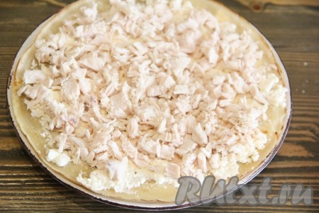 Накрыть начинку вторым блином, слегка прижать, смазать творожной массой и выложить часть нарезанной курицы.
