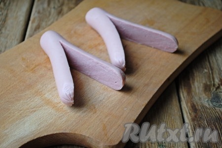 Сосиски, очищенные от плёнки, по центру разрезать вдоль, не доходя, примерно, 1,5 сантиметра до края (как на фото).&nbsp;
