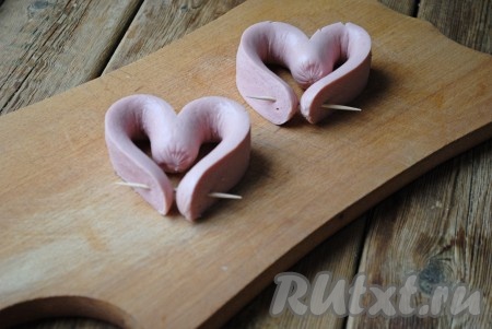 Изогнуть сосиски в виде сердца, скрепить зубочисткой.