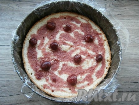 Нижнюю часть большого (первого) бисквита поместить в ту же форму, в которой он выпекался, предварительно тщательно застелив её пищевой пленкой. Пропитать этот бисквит джемом, смешанным с коньяком (я использовала джем с ягодами).
