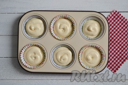 Форму для запекания застелить бумажными формочками или смазать растительным маслом (если используете силиконовую форму - смазывать не нужно). В формочки выложить подготовленное тесто, заполняя их на 2/3 объёма.
