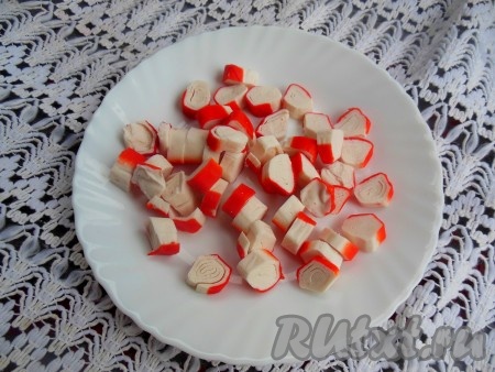 Крабовые палочки нарежьте на небольшие кусочки.
