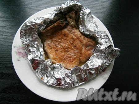 Поместить свиной стейк на кости, завернутый в фольгу, в разогретую до 180 градусов духовку, готовить около 35-40 минут, после чего стейк открыть и запекать его при той же температуре еще минут 10.
