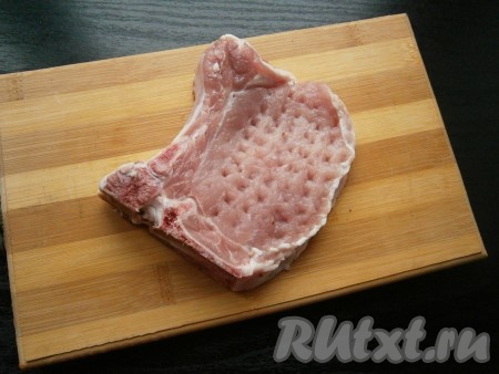 Свиной стейк на кости обмыть, обсушить, отбить слегка молоточком с двух сторон.