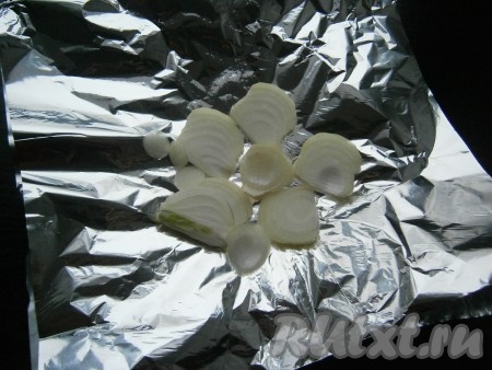 На лист фольги, сложенный вдвое, выложить нарезанный кольцами или полукольцами очищенный репчатый лук.
