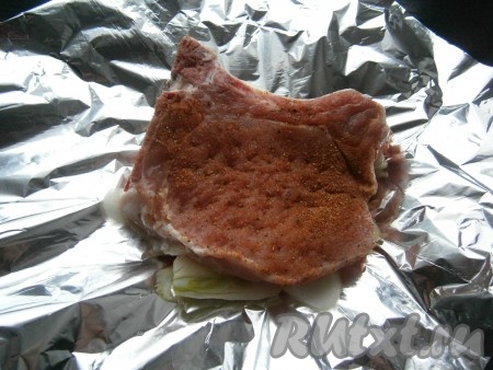 Стейк хорошенько натереть специями и поместить его на лук.