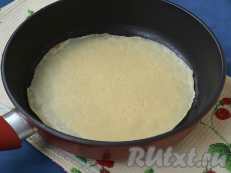 Приступить к жарке блинов. Жарим на хорошо разогретой сковороде на среднем огне. Смазать маслом сковороду и налить тесто, равномерно его распределить. Жарить блин с одной стороны около минуты.
