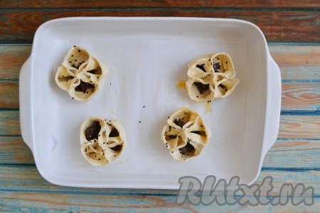 Форму для запекания застелить пекарской бумагой и выложить заготовки слоек. Отправить в разогретую духовку.
