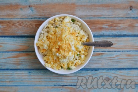 2 яйца, сваренных вкрутую, остудить, очистить и размять вилкой или нарезать ножом на маленькие кубики. Выложить яйца в смесь сыра и лука.