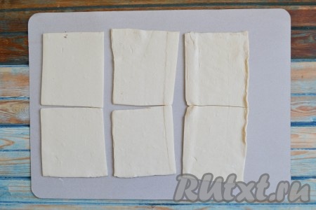 Замороженное слоеное тесто разморозить. Лучше размораживать тесто&nbsp; в холодильнике, оставив его там на ночь. Если нет времени ждать, можно разморозить тесто в микроволновке на режиме "Разморозка". Аккуратно развернуть размороженное тесто на пергаменте и разрезать на квадраты одинакового размера (я нарезала на квадраты, примерно, 8х8 см).
