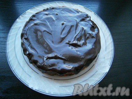 Дать глазури остыть до теплого состояния. Тортик вынуть из формы, убрать пленку и покрыть его сверху глазурью, размазав ее по всей поверхности.