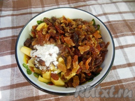 Изюм залейте горячей водой на 2 минуты, воду слейте. Обсушите изюм с помощью бумажного полотенца. Яблоки очистите от кожуры и семенной коробочки, нарежьте на небольшие кусочки. Перемешайте яблоки с изюмом и крахмалом.
