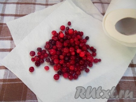 Клюкву промойте, положите на бумажное полотенце. Затем промокните, чтобы ягодки были максимально сухими. Добавьте к клюкве крахмал и перемешайте.
