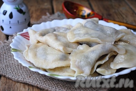 Готовые вареники вынуть из воды с помощью ситечка. Выложить в миску и добавить сливочное масло. 
