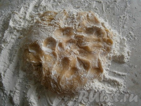 Оставшуюся часть муки насыпать на стол и выложить в нее тесто. Руками замесить тесто. Тесто будет мягким и липким, но муки больше не добавляйте.