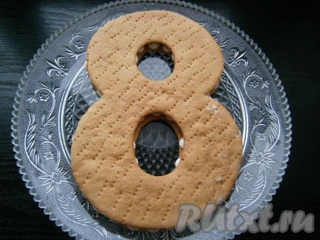 Сверху, не слишком придавливая, выложить второй корж.