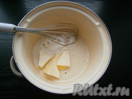 Затем добавить размягченное сливочное масло и поместить кастрюльку (или ковшик) на небольшой огонь.
