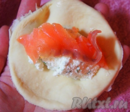 Сёмгу нарезать тонкими кусочками. Подошедшее бездрожжевое тесто на кефире раскатать, кружкой или формой вырезать "кружки", положить творожный крем, семгу и аккуратно защипнуть края чтобы придать форму пирожка.
