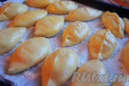 Противень застелить пергаментной бумагой, присыпать мукой. На каждом пирожке сделать по несколько "наколов" вилкой и переложить на застеленный противень.
