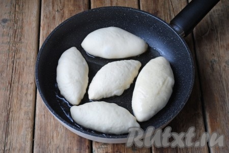 Подошедшие пирожки будем жарить на разогретой сковороде с добавлением достаточного количества растительного масла. Выложить пирожки швом вниз.