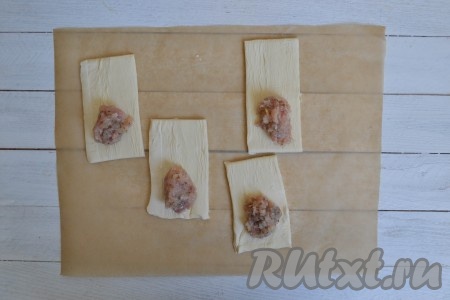 На один край теста щедро выложить подготовленный фарш. 