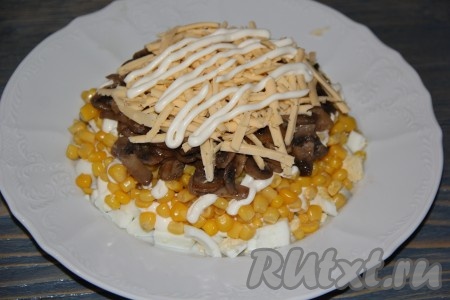 Сыр натереть на крупной тёрке. Часть сыра выложить на грибы и сделать решетку из майонеза.