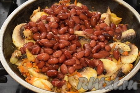 Из банки с консервированной фасолью слить жидкость и промыть фасоль до прозрачности под проточной водой. К шампиньонам добавить фасоль.