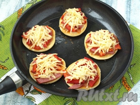 Каждый оладушек, по желанию, посыпать специями (я посыпала орегано). Поверх начинки выложить натёртый сыр. Сковороду накрыть крышкой и жарить оладьи а-ля пицца на медленном огне 3-5 минут (до поджаривания оладий снизу и расплавления сыра).&nbsp;