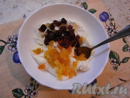 В творожную массу добавить мелко нарезанную курагу (если курага жесткая, её нужно замочить в кипятке минут на 10 и обсушить) и вяленую клюкву.
