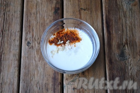 В миску налить кефир (процент жирности кефира в данном рецепте не играет никакой роли, выбирайте на свой вкус), добавить соль и приправу к курице. Чеснок очистить и мелко нарезать или пропустить через пресс, также добавить к кефиру. Перемешать получившийся кефирный маринад.
