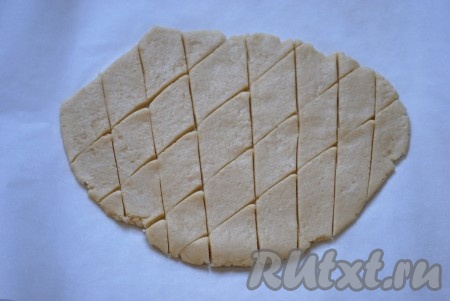 Выложить тесто на пергаментную бумагу и раскатать в пласт толщиной 0,5 см. Острым ножом разрезать на ромбы или квадраты, желаемых размеров.
