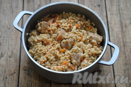 Готовый плов снять с огня и дать настояться под крышкой 10-15 минут. Затем плов из перловки со свининой перемешать, разложить по тарелкам и подать к столу.&nbsp;

