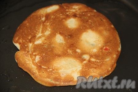 Жарить блинчик с двух сторон до золотистого цвета на среднем огне, затем переложить на тарелку. А из оставшегося теста постепенно пожарить все блины, складывая их на тарелку.
