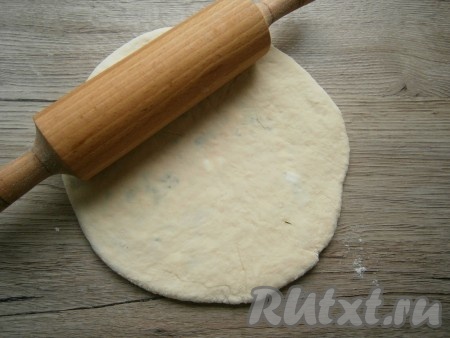 Далее тесто с творогом придавить рукой и раскатать в тонкую лепешку.
