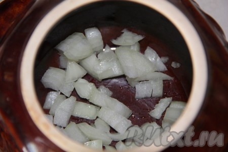 На дно каждого горшочка кладём по половине очищенной и мелко нарезанной луковицы.