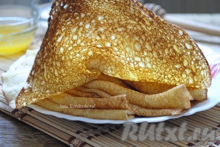 Вкусные, нежные блины сразу подавать на стол со сметаной или мёдом. На фото видно, какими кружевными получаются блинчики, приготовленные на сыворотке по этому рецепту.