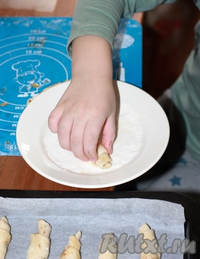 Каждый рогалик снова смазать яйцом и обвалять в сахаре.