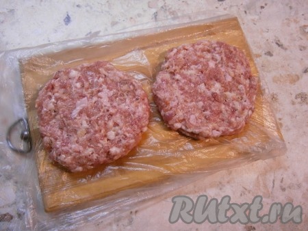 Досочку застелить целлофаном и на нем сформировать мокрыми руками два больших шницеля. Целлофан нужен для того, чтобы в дальнейшем шницели легко было взять, не повредив их форму.
